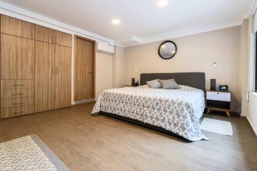a bedroom with a bed and a clock on the wall at 102 Centro 2Bdrm 2bath apt AC Rooftop in Mexico City