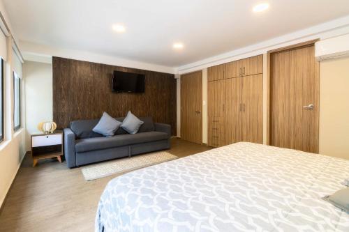 a bedroom with a bed and a couch at 102 Centro 2Bdrm 2bath apt AC Rooftop in Mexico City