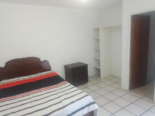 a bedroom with a bed and a dresser and a closet at Hostal Irma in Durango