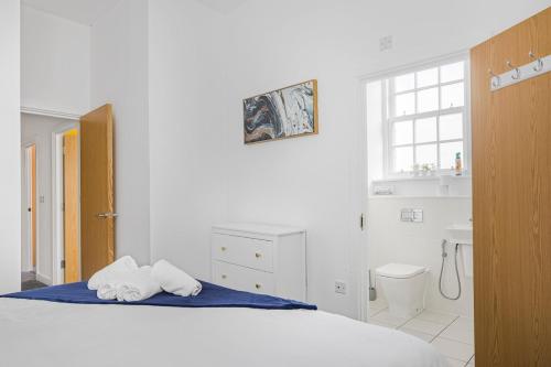 WrittleにあるBright & Modern 3 Bed Home I Sleeps 5の白いベッドルーム(タオル付きのベッド付)
