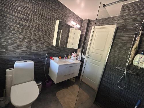 a bathroom with a toilet and a sink and a shower at Två sovrum fyra sängar Koppla av med hela familjen i detta fridfulla boende in Kalmar