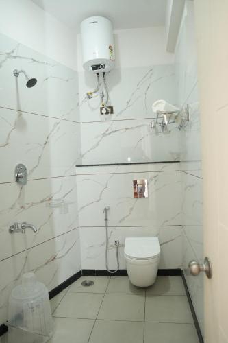 un bagno bianco con wc e doccia di Pallakki Comforts Chikmagalur a Attigundi