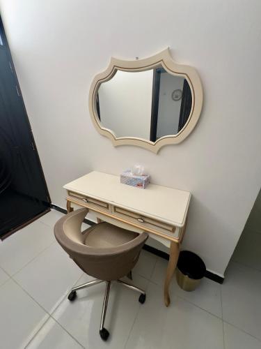 a dressing table with a chair and a mirror at رخاء للغرف الفندقية in Firq