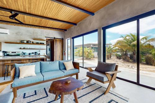 a living room with a blue couch and a table at Seabird - Villa 20 in Placencia Village