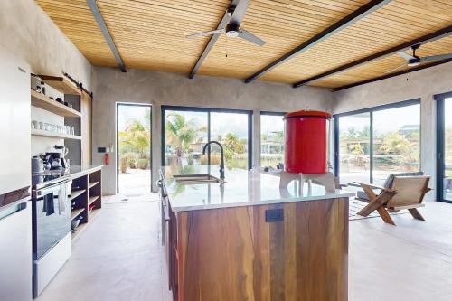 a kitchen with a large island with a red appliance at Seabird - Villa 20 in Placencia Village