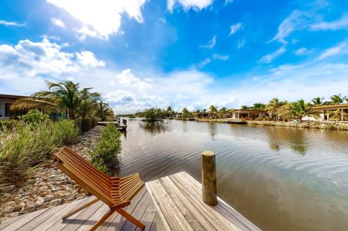 a bench sitting on a dock next to a river at Seabird - Villa 20 in Placencia Village