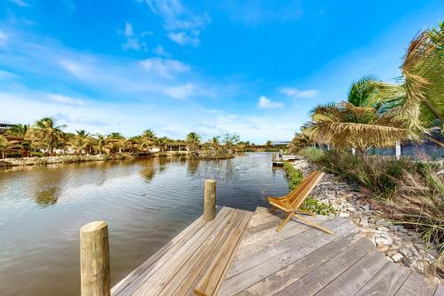 a wooden dock with a bench on the water at Seabird - Villa 20 in Placencia Village