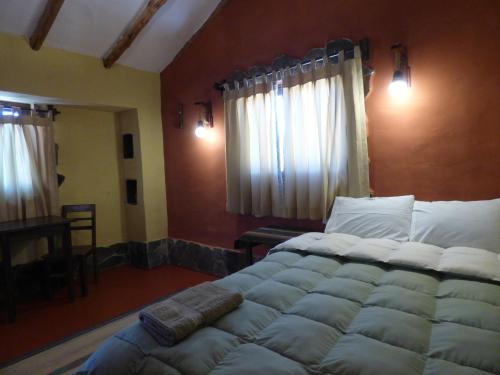 a bedroom with a large bed with white pillows at Lodge Mirador San Antonio- Colca in Coporaque
