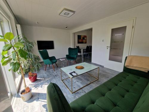 a living room with a green couch and a table at Cozy modern newly renovated home in Kassel in Kassel