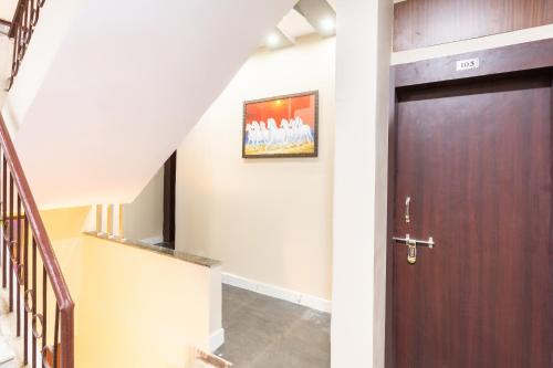 a hallway with a wooden door and stairs at Hotel O Savitri Regency in Bhopal