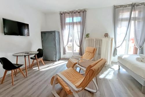 a living room with a couch and a table and chairs at Large studio avec terrasse in Amélie-les-Bains-Palalda