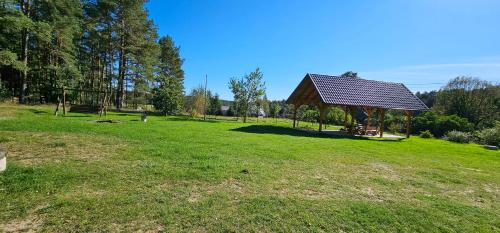 a gazebo in the middle of a grass field at Leśna Przystań Bory Tucholskie in Łuby