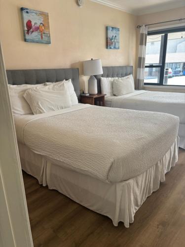 two beds in a hotel room with two beds at Peach Tree Inn in San Luis Obispo