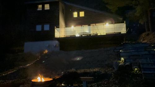 a fire in front of a house at night at Cabin G Lake Saiko 1min, MtFuji View, BBQ, Hammock, fire pit in Narusawa