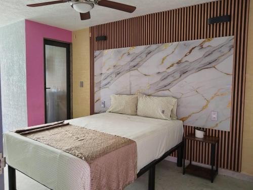a bedroom with a bed with a marble wall at HOTEL SOL in Guadalajara