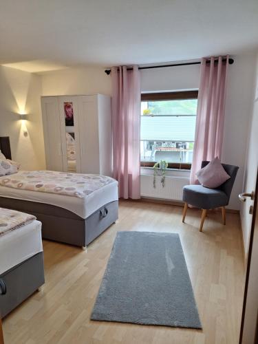 ベルンカステル・クースにあるFeriennest Zitaのベッド2台と椅子と窓のある寝室