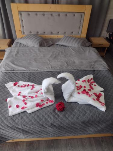 a bed with two towels and roses on it at Dream House in Krivorovnya