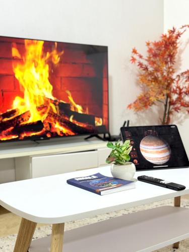 a living room with a fireplace and a white table at Peaceful and Spacious Apartment at Luanda Bay in Luanda
