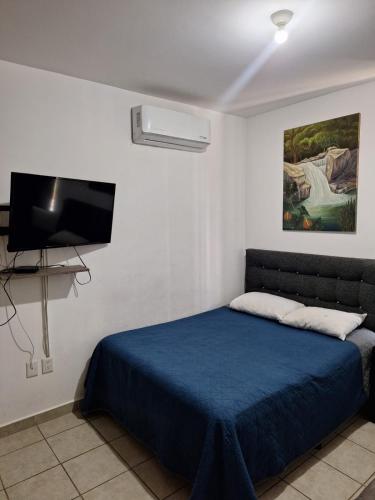 une chambre avec un lit et une télévision à écran plat dans l'établissement Apartamento con picina en zona hotelera, à Puerto Vallarta