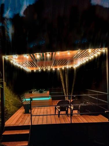 a deck with two chairs and lights on it at Cabina con Jacuzzi cerca al Peñol in Chiquinquirá
