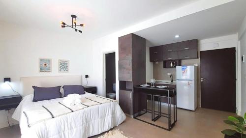 Un dormitorio con una cama y una cocina con fregadero. en G & A Rent Ezeiza, en Ezeiza