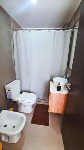 Un baño con un inodoro blanco y un lavabo. en G & A Rent Ezeiza, en Ezeiza