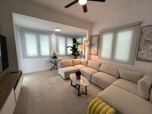 a living room with a couch and a tv at Elegant Home with KingBed Private Patio Ensuites in San Juan