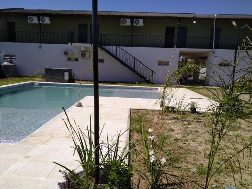 a swimming pool in front of a house at Rdsa Paso in Paso de la Patria