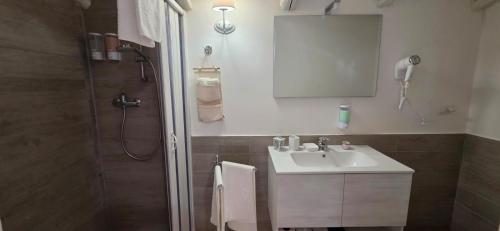 a bathroom with a sink and a shower with a mirror at ALETNA Home in Ragalna