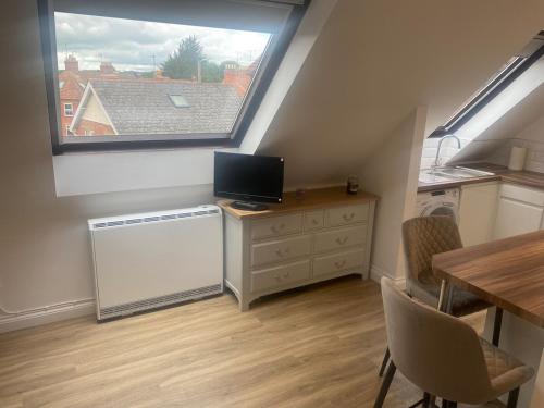 a kitchen with a window and a table and a television at Modern 1 bedroom flat in useful location in Yeovil