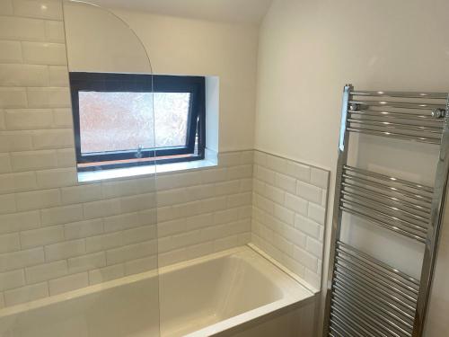 a bathroom with a bath tub and a window at Modern 1 bedroom flat in useful location in Yeovil