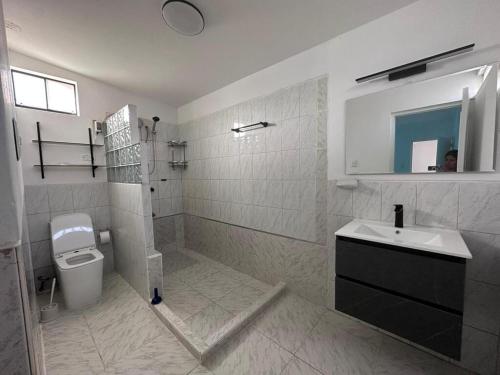 ルリンにあるCasa amplia con Piscina privada y a pasos de la playaの洗面台とトイレを備えた白いバスルーム