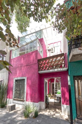 a pink building with a balcony on it at Departamentos Mi querido Coyoacán in Mexico City