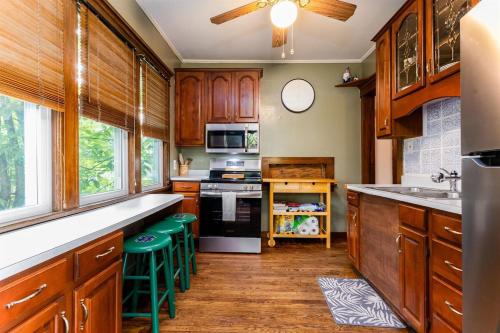 a kitchen with wooden cabinets and green stools at The ND Rover - Vintage 4BR Home Across St to ND in South Bend