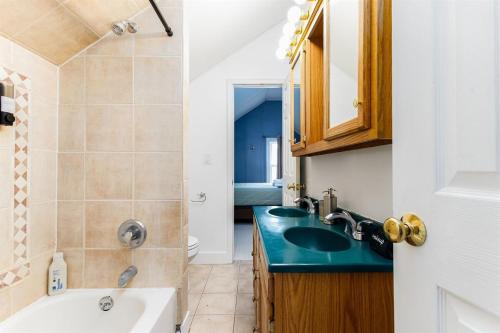 a bathroom with a sink and a toilet and a tub at The ND Rover - Vintage 4BR Home Across St to ND in South Bend