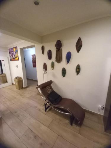 a room with a chair and some art on the wall at LA SUNSET in Accra