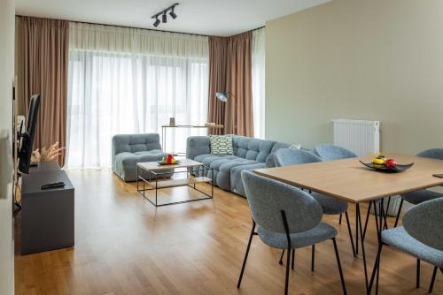 ein Wohnzimmer mit einer Couch und einem Tisch und Stühlen in der Unterkunft Limak's Diamond Residences in Skopje