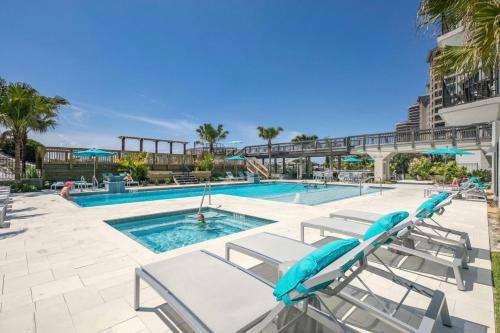 a swimming pool with chaise lounge chairs next to a swimming pool at Beachside One 4023 in Destin