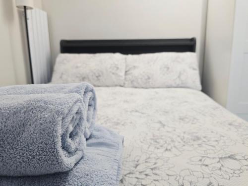 an unmade bed with a blanket on top of it at Cosy studio Victoria in London