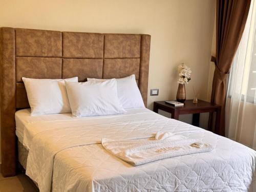 a bed with a blanket and a towel on it at Hotel Margarita in Flores