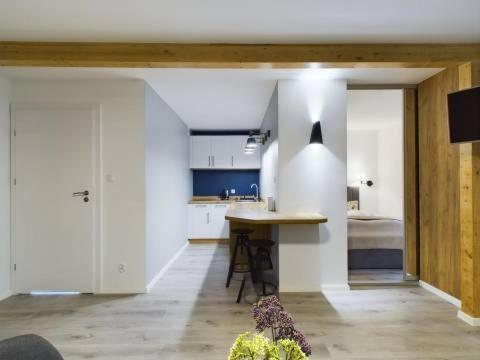 a kitchen with white cabinets and a table in a room at Apartamenty Familly Dąbrówka - przy parku, prywatny parking, sauna, ogód - by SpaceApart in Jelenia Góra