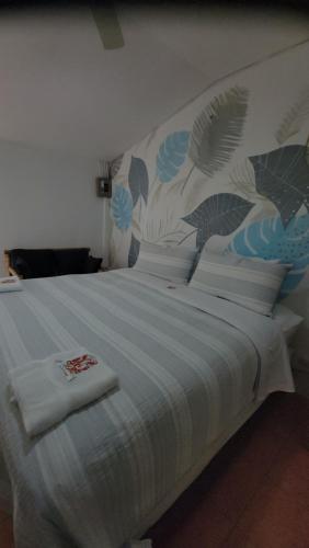 a large bed with a blue and white comforter at Las sevillanas beach hotel y restaurante in Gemastepe