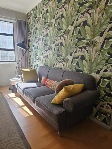 a couch in a living room with a floral wall at Designer 1 bedroom Vacation Rental Cape Town in Cape Town