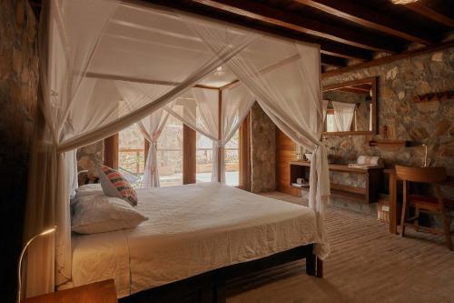 a bedroom with a canopy bed and a desk at Casa del Mar AC Rustic design Pool Paceful in Santa María Tonameca
