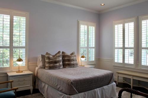 Un dormitorio con una cama con almohadas y ventanas. en The Top at Round Top, en Round Top