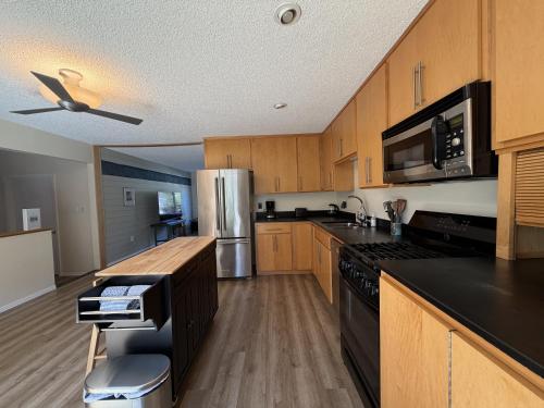 a kitchen with wooden cabinets and a stainless steel refrigerator at Wavesong Refuge in McKinleyville