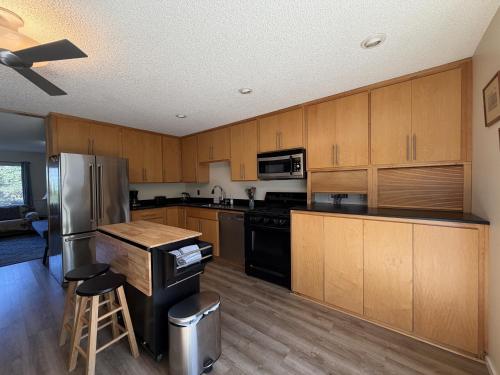 a kitchen with wooden cabinets and a stainless steel refrigerator at Wavesong Refuge in McKinleyville