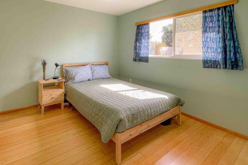 a bedroom with a bed and a window at Wavesong Refuge in McKinleyville
