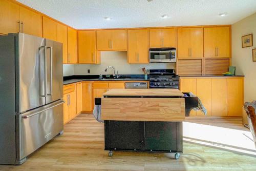 a kitchen with wooden cabinets and a stainless steel refrigerator at Wavesong Refuge in McKinleyville