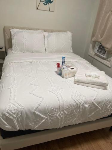 a white bed with a tray of items on it at Sammy Place in Newark